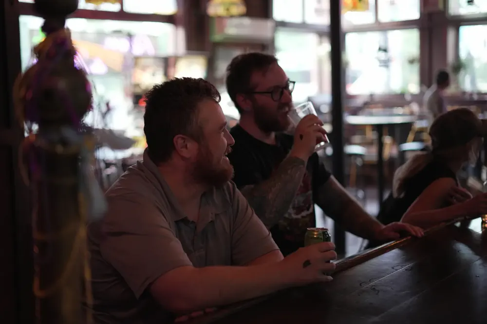 Two friends at the bar with drinks