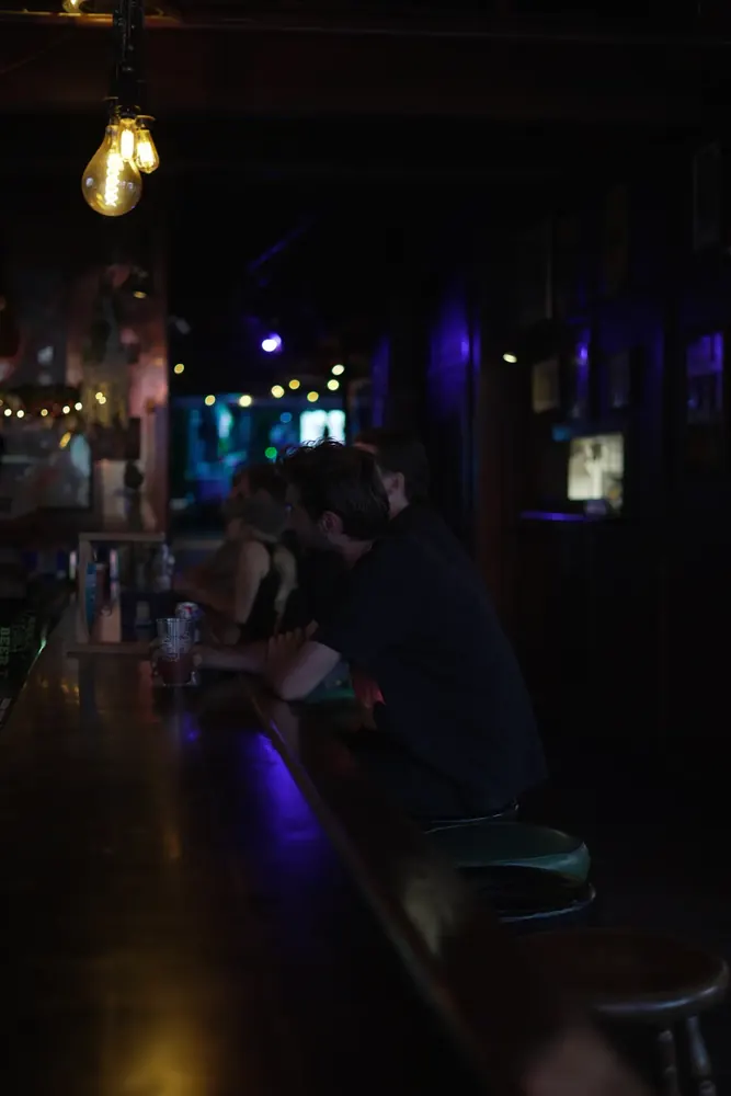 The long bar at Ophelia's under an Edison bulb